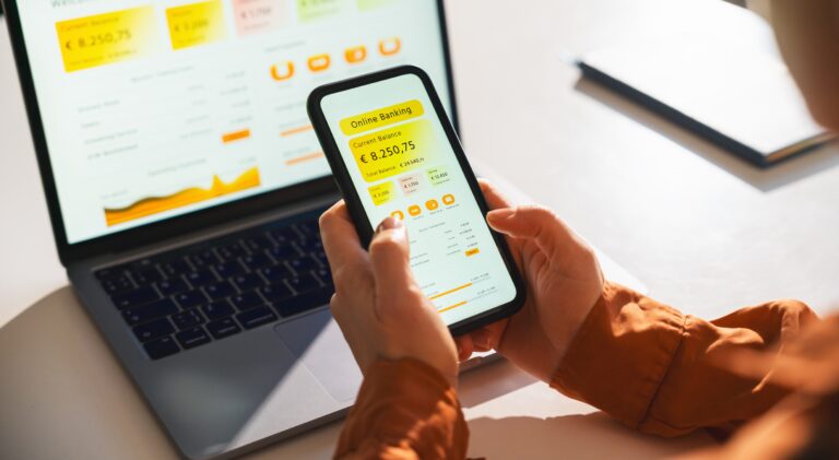 Conto corrente aziendale zero spese, una persona controlla da smartphone e da laptop il credito del conto aziendale