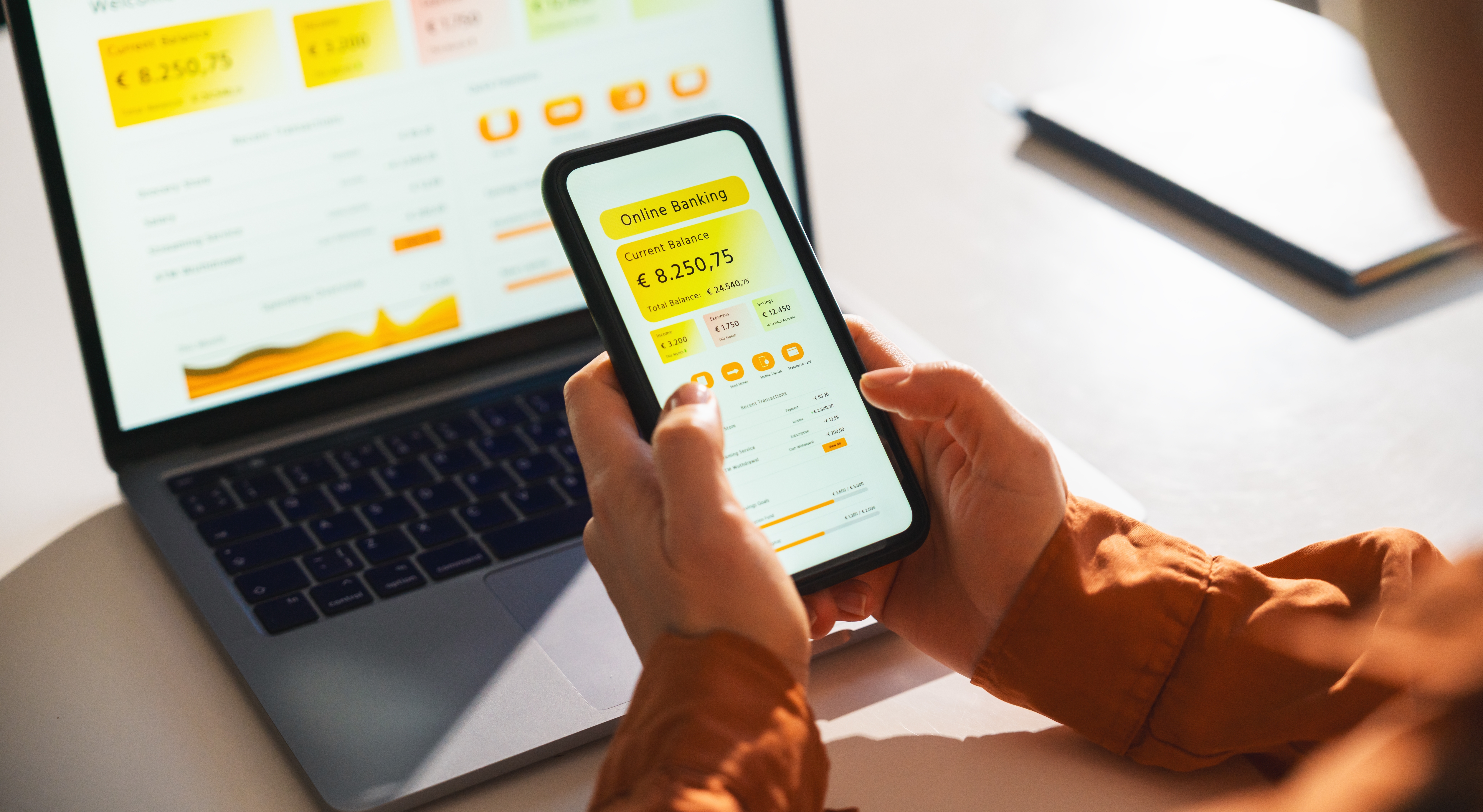 Conto corrente aziendale zero spese, una persona controlla da smartphone e da laptop il credito del conto aziendale
